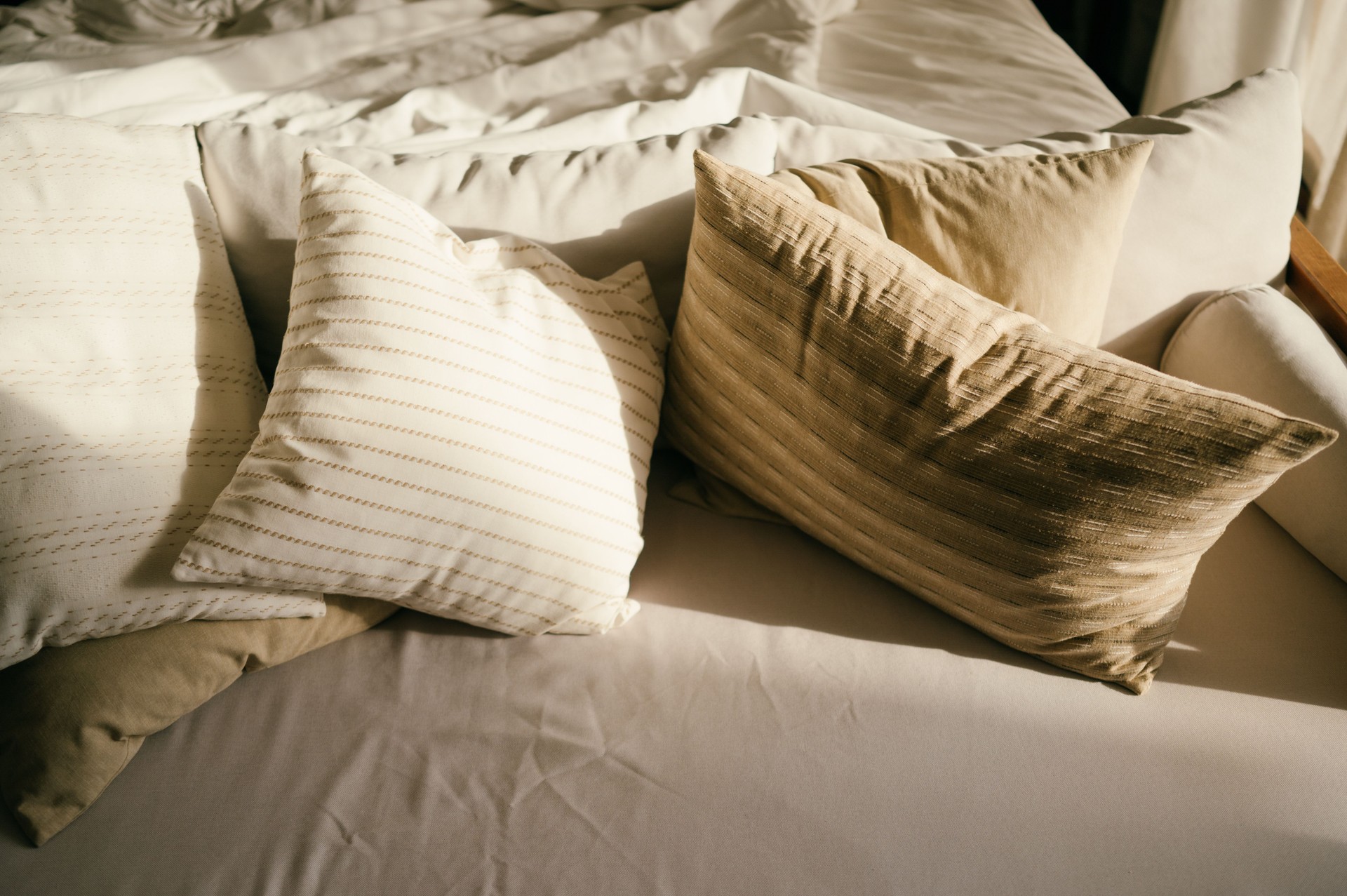 modern luxury bedroom with stylish cushions and warm-toned bed linens  cozy bedroom with soft neutral pillows and elegant minimalist bedding